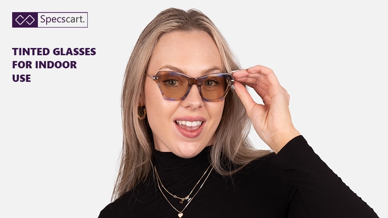 A smiling woman with blonde hair wearing geometric cat-eye glasses with brown-tinted lenses and a tortoise-shell frame.