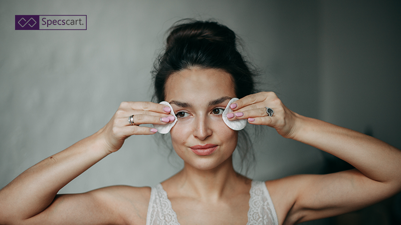 Woman gently cleansing her eyes with cotton pads, illustrating a natural and safe makeup removal routine.