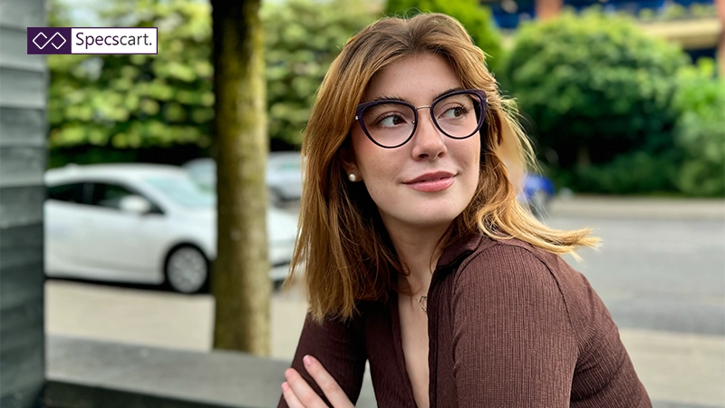Woman wearing trendy dark purple cat-eye glasses for Specscart 2025 women's eyeglasses trends.