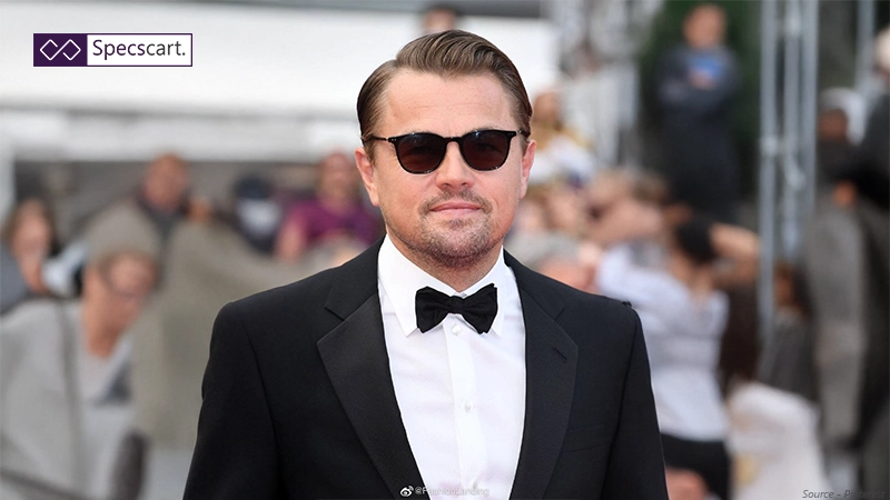 The 5 Most Iconic Leonardo Dicaprio Sunglasses and Glasses Leonardo DiCaprio in a black tuxedo and bow tie, wearing classic black-rimmed sunglasses on the Cannes Film Festival red carpet.
