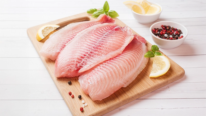 Raw fish fillets on a wooden board with lemons, highlighting omega-3 fatty acids as a top food for healthy eyes.