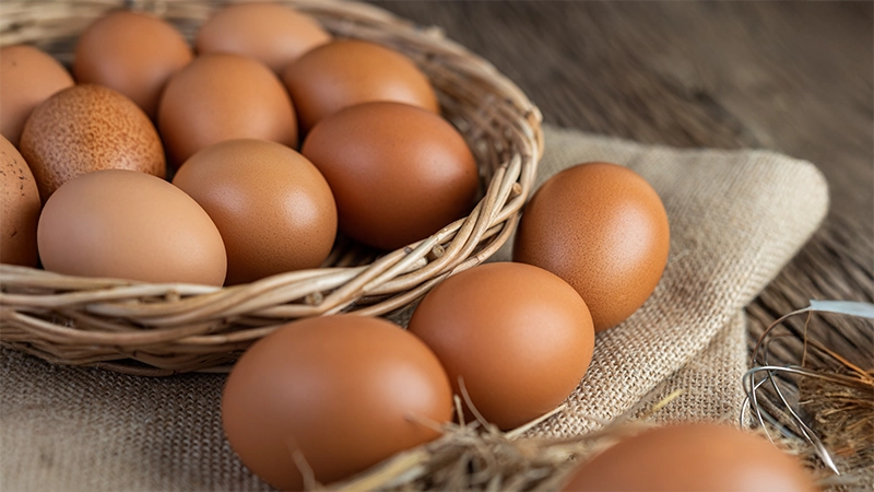 Fresh brown eggs in a wicker basket, highlighting lutein-rich foods that protect and support healthy eyes.