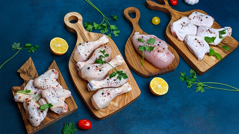 Raw chicken cuts on wooden boards, highlighting zinc-rich poultry as a top food choice for healthy eyes.