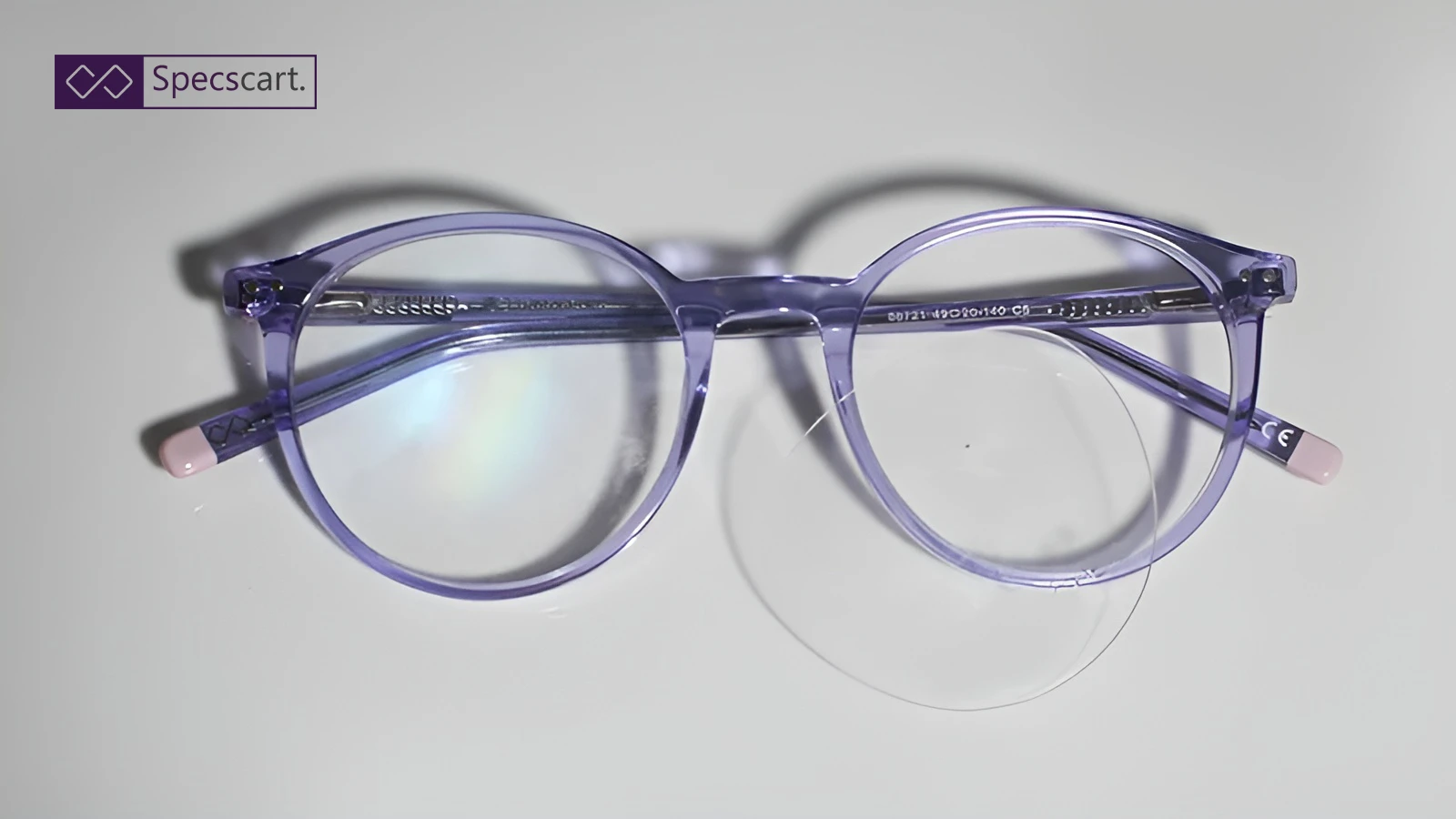 A pair of stylish, round purple eyeglasses with one lens completely popped out of the frame, illustrating the common issue of loose or popped-out lenses.