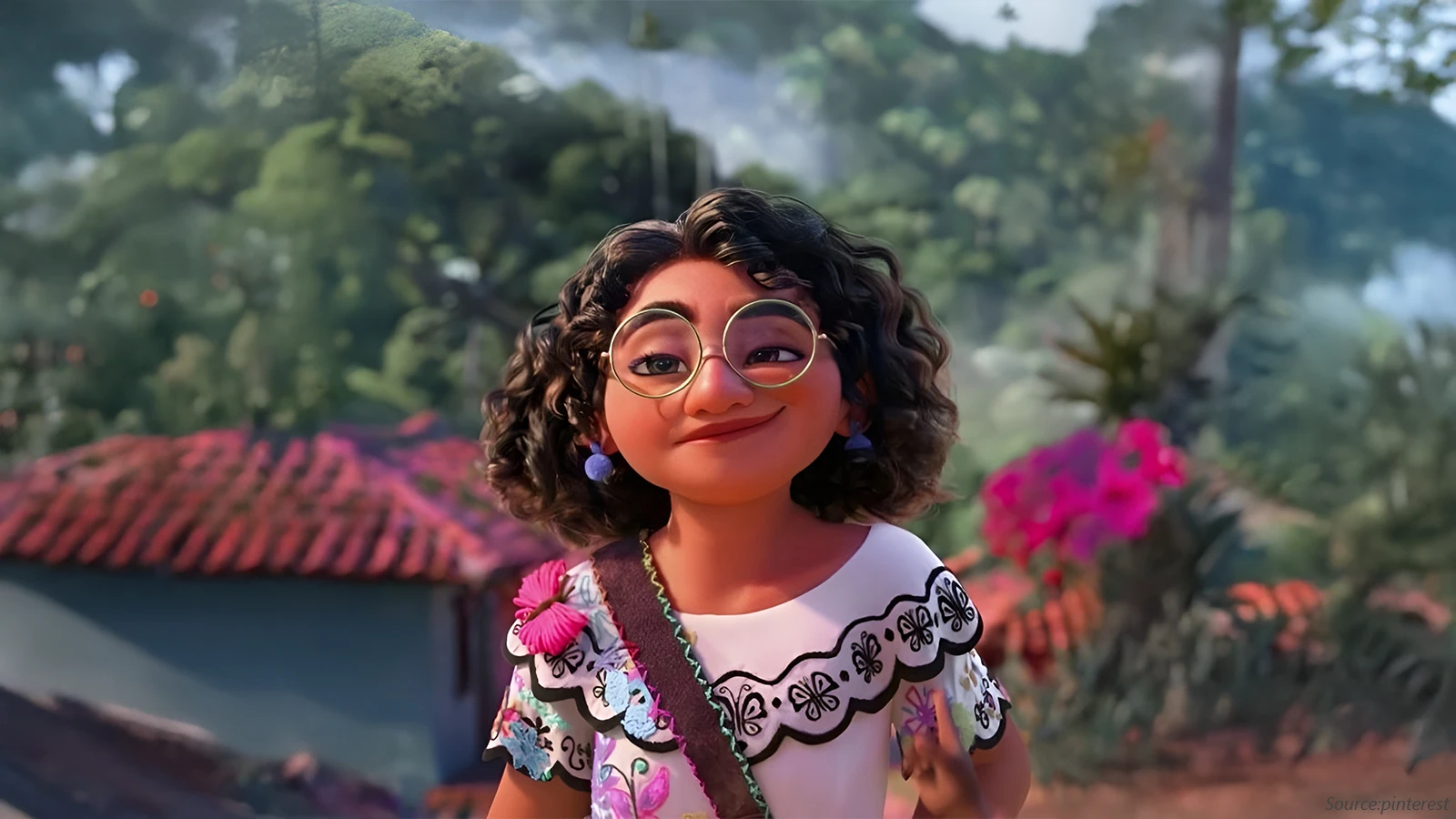 A CGI close-up of Mirabel Madrigal from Encanto smiling playfully. She wears a white embroidered top, a pink butterfly clip, blue pom-pom earrings, and her large, round green-rimmed glasses.