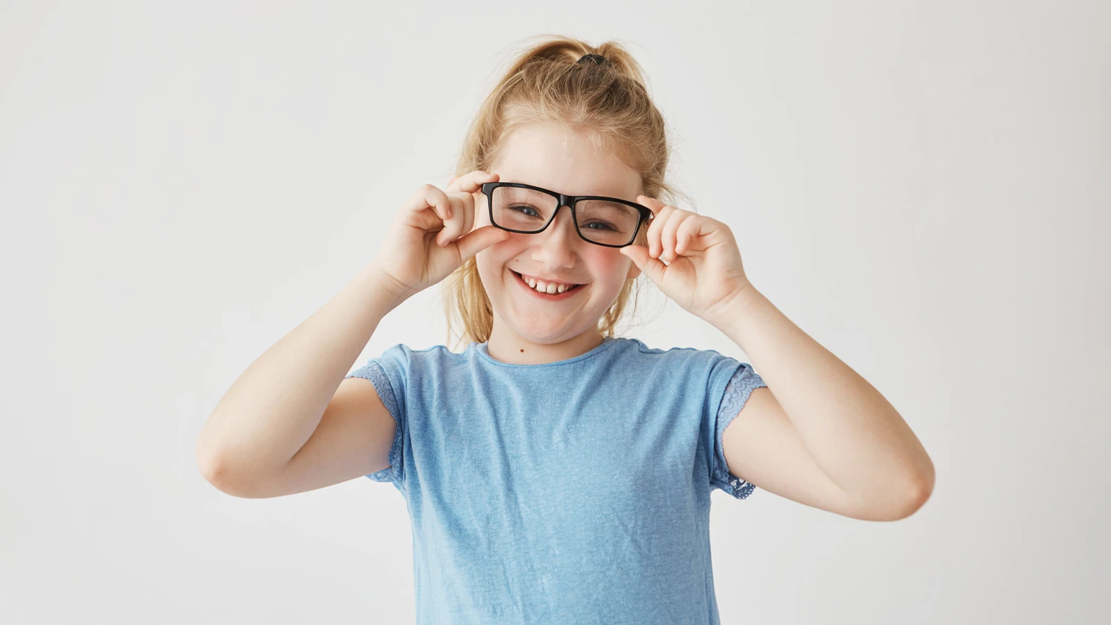 Young girl wearing black frames, demonstrating comfortable eyewear for children with vision conditions like Nystagmus.