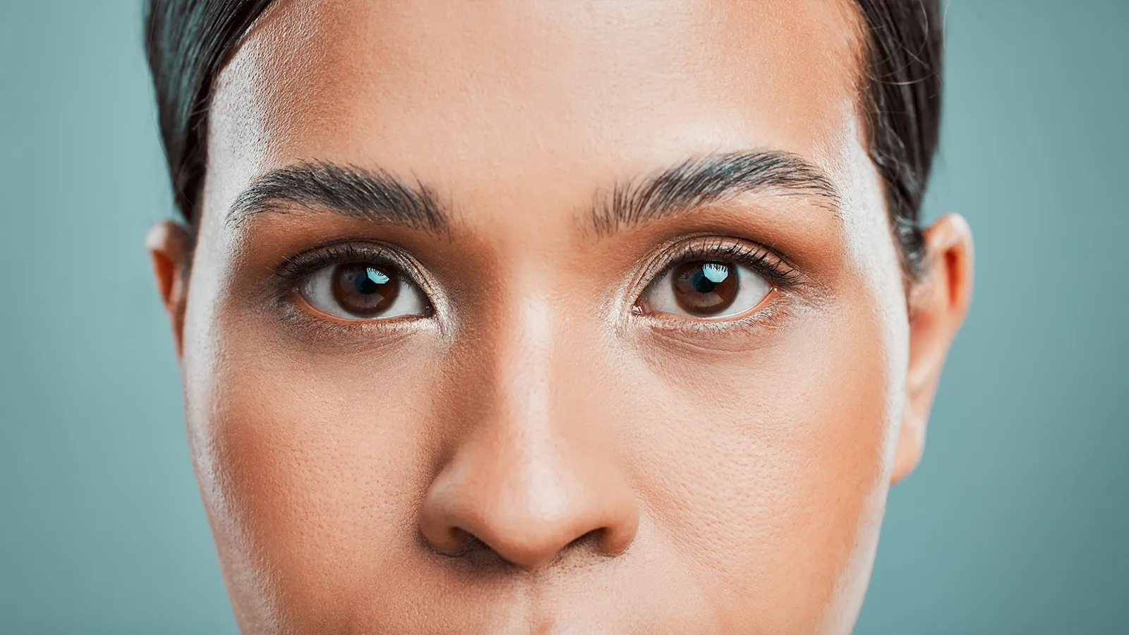 Extreme close-up portrait focusing on the eyes and brow area, highlighting the natural skin tone and any signs of periorbital darkness or shadows.