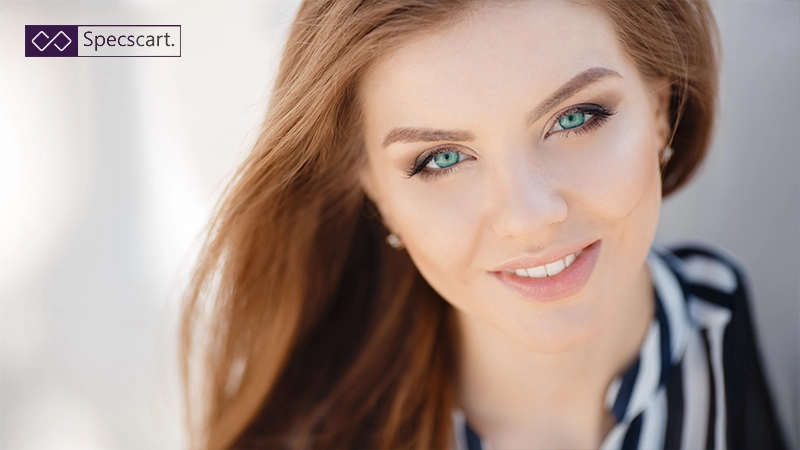A beautiful woman with flowing auburn hair and striking turquoise-green eyes.