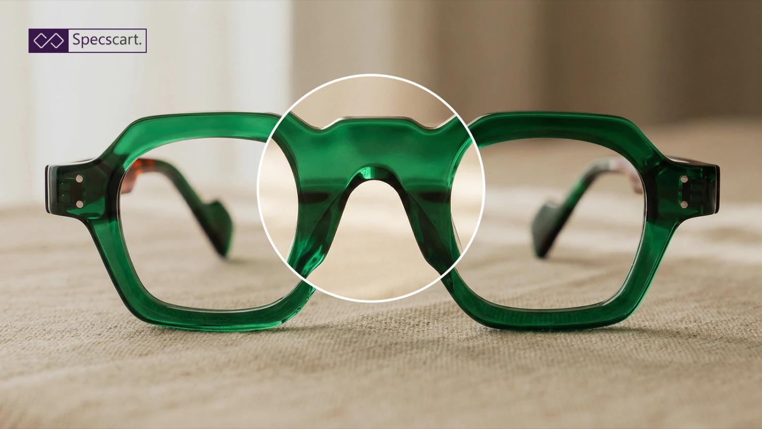 Close-up of green acetate glasses with a magnified view of the saddle nose bridge, highlighting the frame's design and fit on a neutral background.