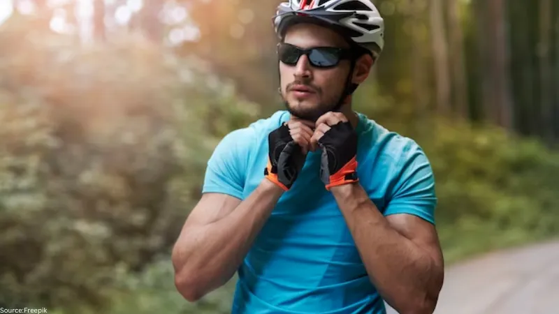 Professional cyclist wearing wrap-around sunglasses, highlighting the importance of eye protection for outdoor riding.