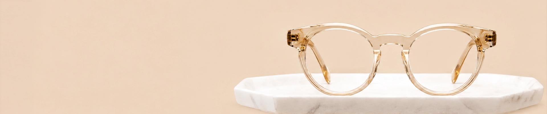 Oval Glasses Bold amber-coloured oval eyeglasses with thick round rims, displayed on a clean white background