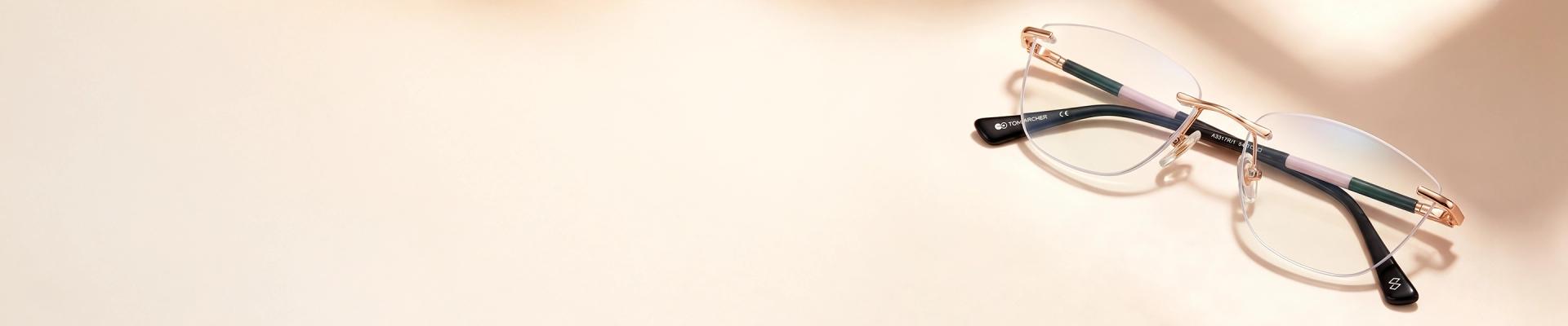 Rimless Glasses Minimalist rimless eyeglasses with rectangular lenses, silver bridge and temples, and black temple tips, shown on a light grey background