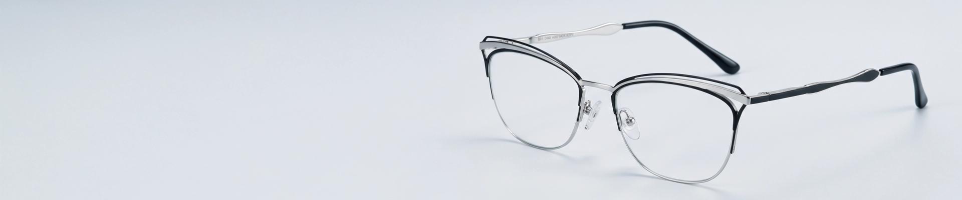 Silver Glasses Silver metal oval glasses with black temple tips displayed on minimalist mint green pedestals.