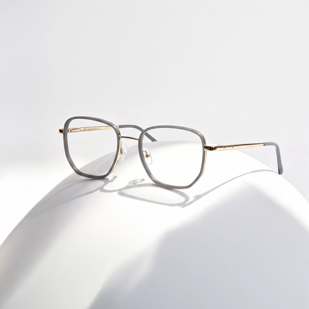 Translucent champagne geometric glasses with textured temples casting a reflection on a glossy rose gold background.