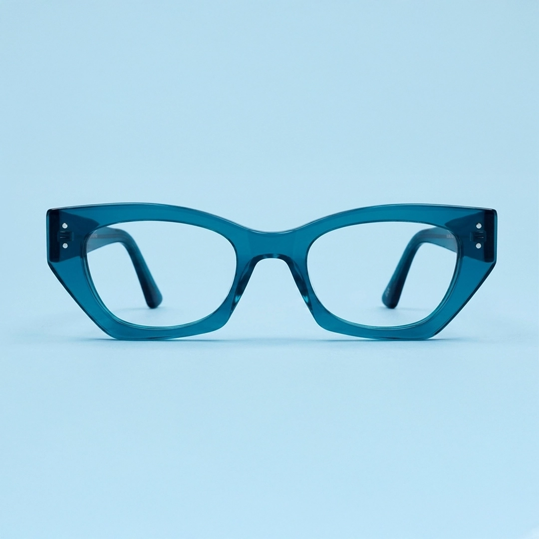 Blue Glasses Glossy round blue eyeglasses with keyhole bridge, placed upright on a white marble surface with matching marble background
