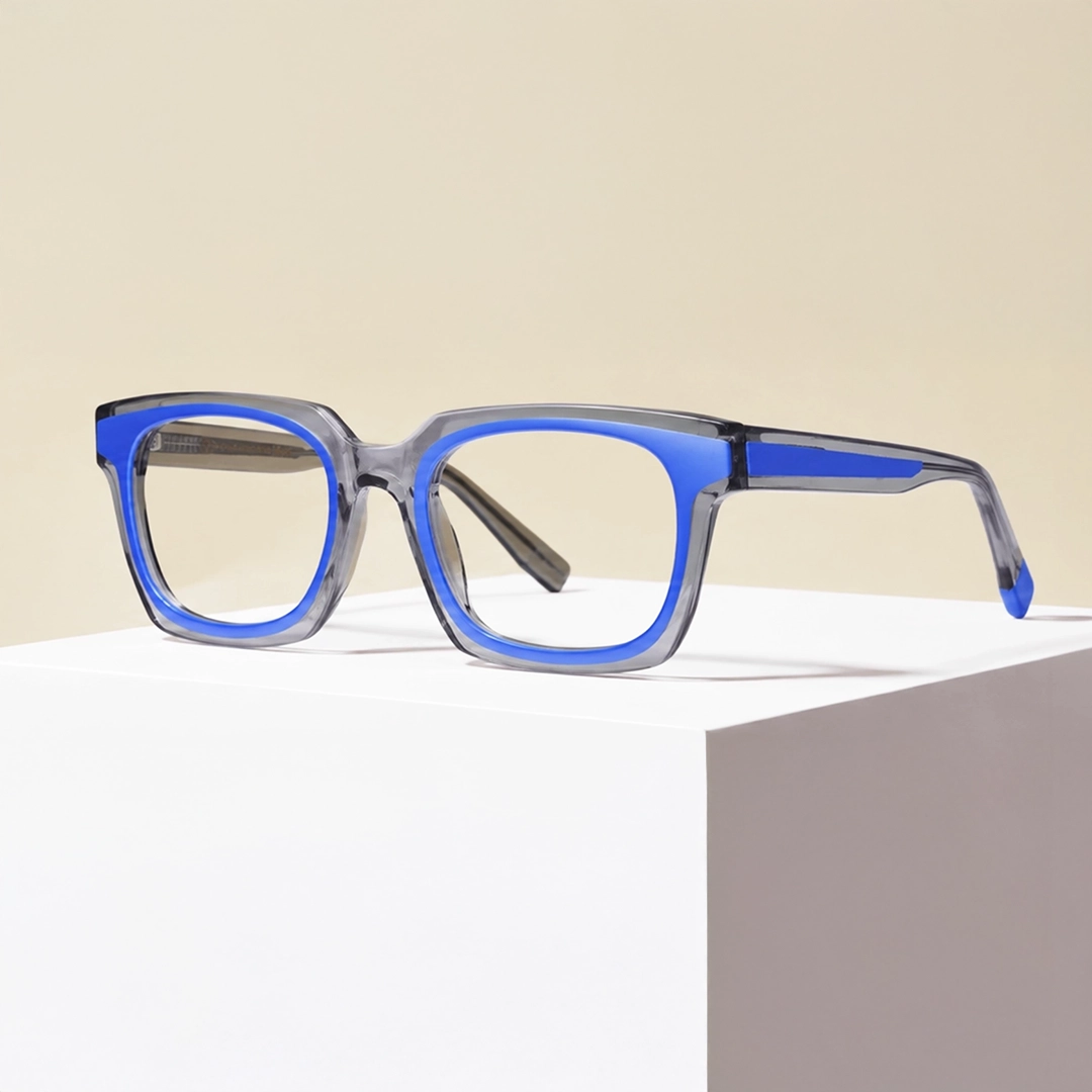 Blue rectangular glasses frames placed on a lime green desk next to a laptop, showcasing stylish and affordable eyewear for daily work.
