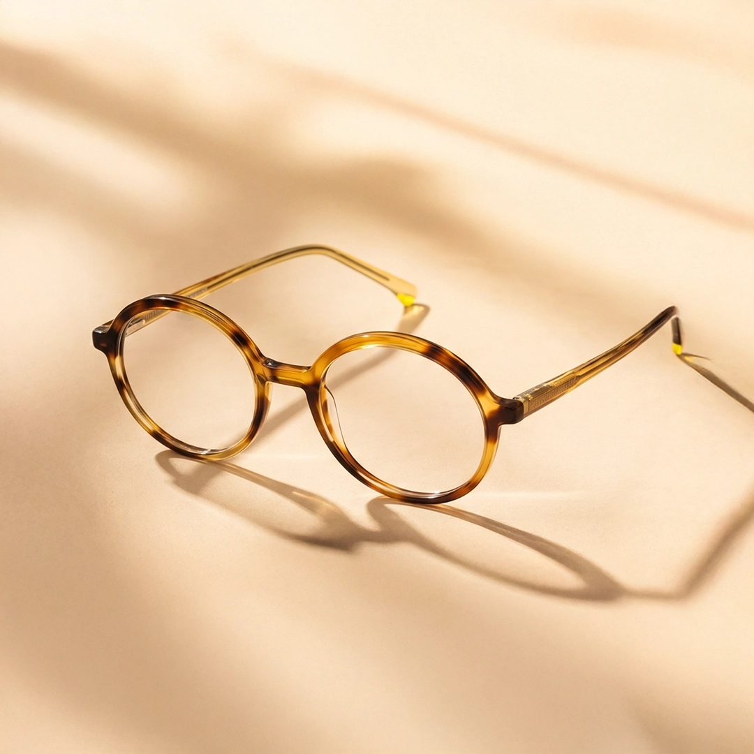 Yellow Glasses A smiling woman wearing stylish, oversized yellow and black round glasses looks up and to the side against a pale yellow background.