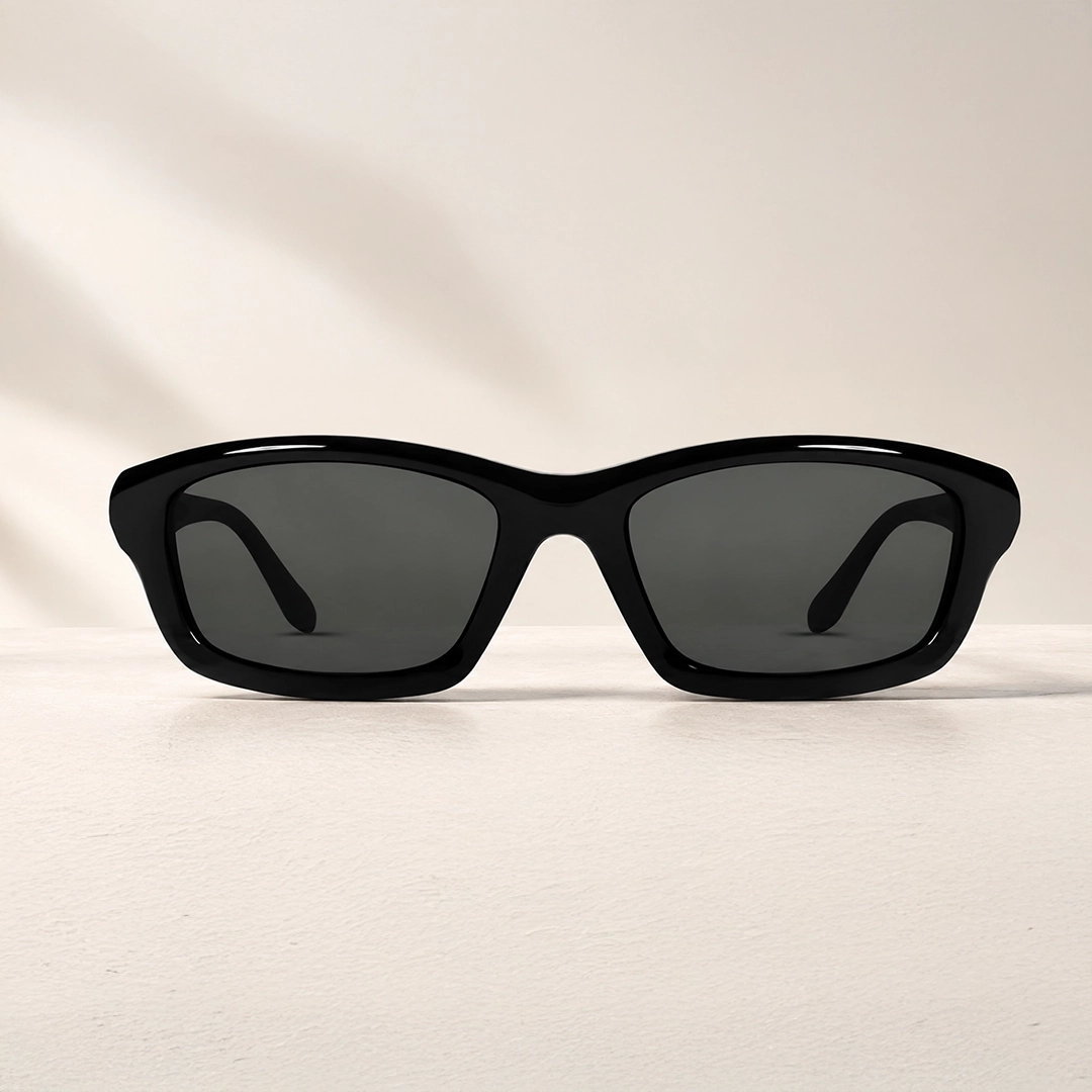 A smiling blonde woman wearing elegant round metal sunglasses with gradient varifocal lenses, set against a soft, out-of-focus professional backdrop.