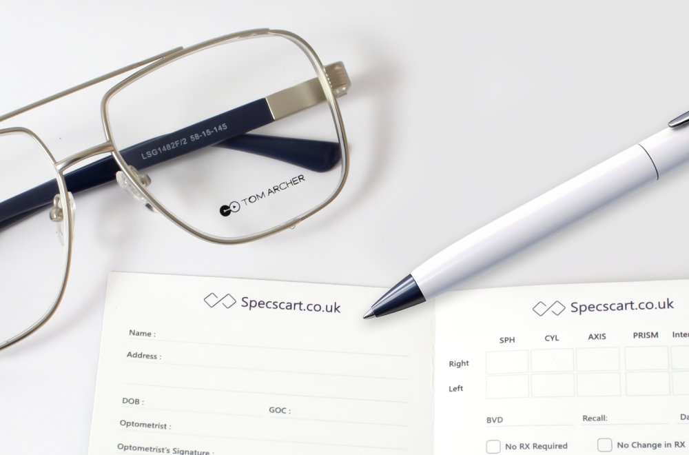 Close-up image of a pair of gold-rimmed eyeglasses and a white pen laid next to two Specscart prescription pads, one for personal details and the other for optical measurements, demonstrating the components of an eye prescription.