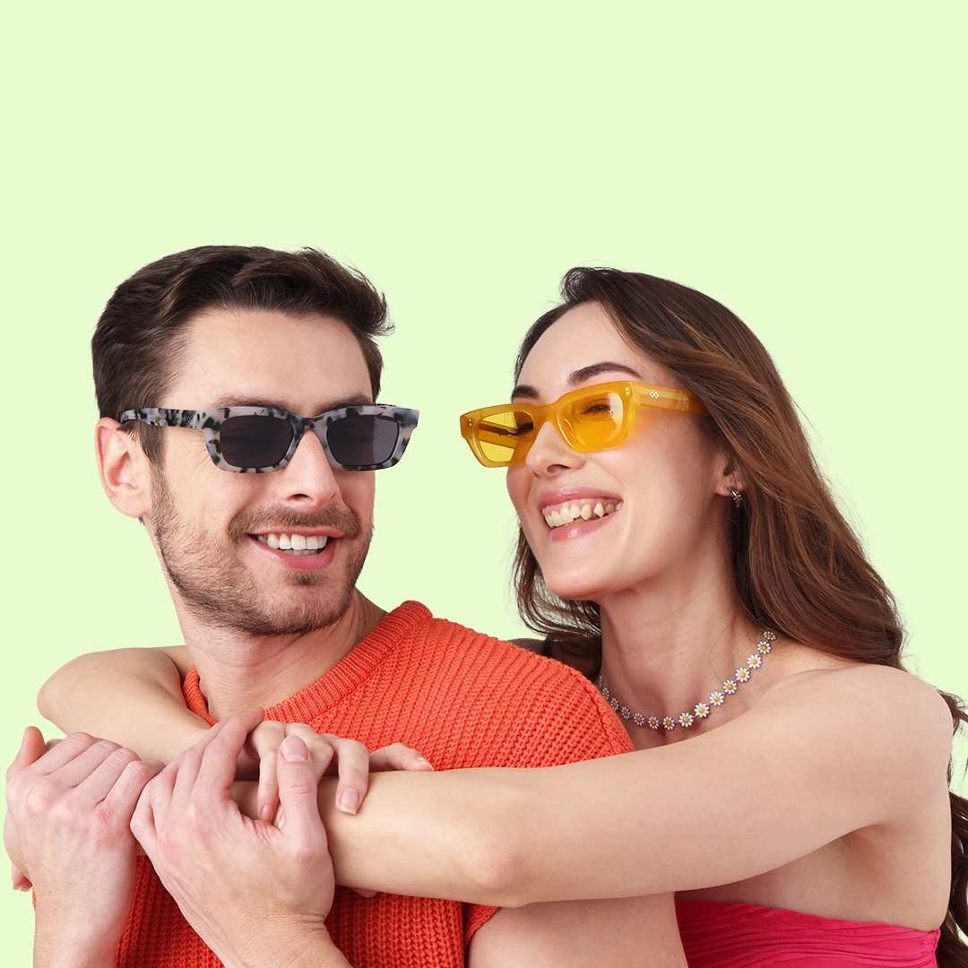Rectangular Sunglasses Smiling man in an orange sweater wearing grey patterned rectangular frames and a woman in yellow rectangular sunglasses, against a green background.