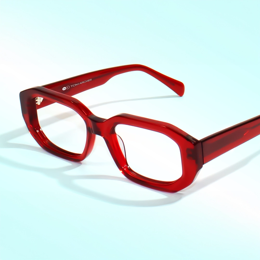 Red Glasses Close-up of stylish, bold, square glasses with bright, translucent red frames on a light blue background.