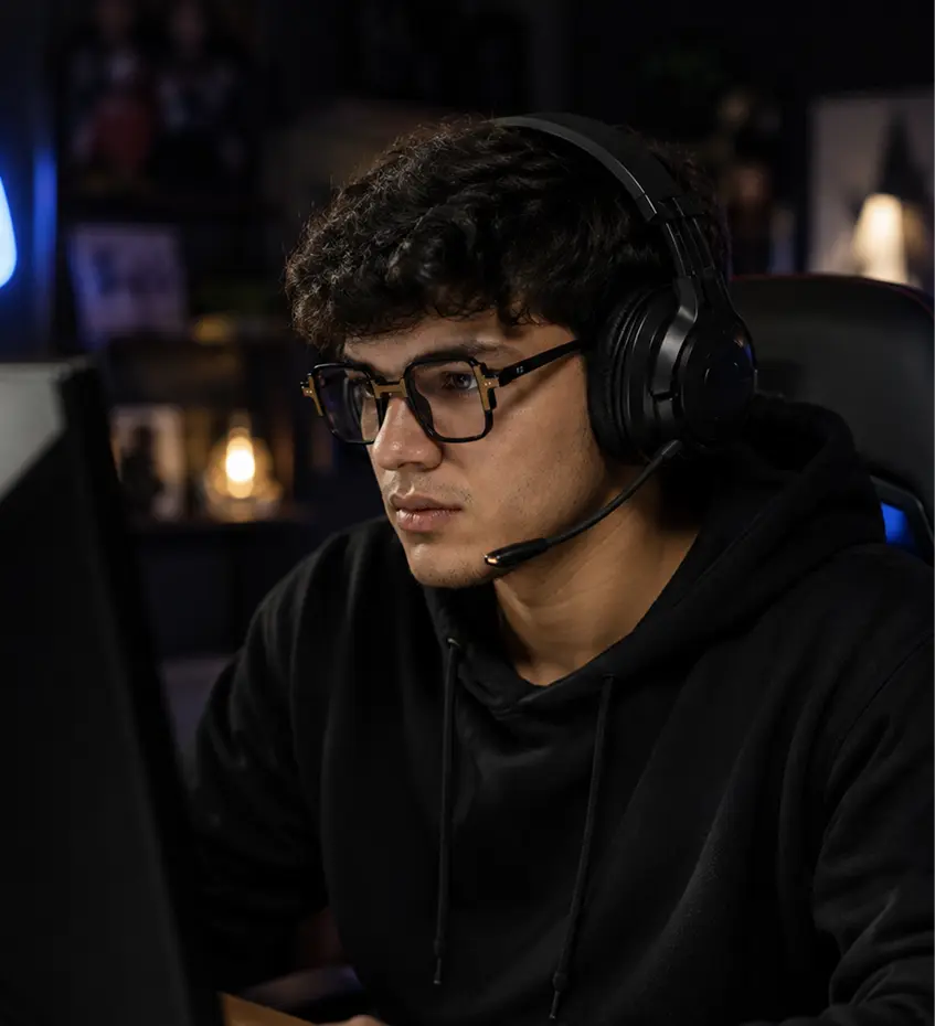 Young man wearing Specscart black round blue light glasses and gaming headphones, illustrating eye protection for intensive computer use.