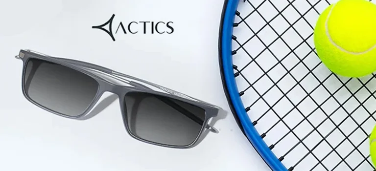 Sports Sunglasses Two pairs of rectangular sports sunglasses with grey and teal lenses, displayed next to a tennis racket and ball with the Actics logo on a white base.