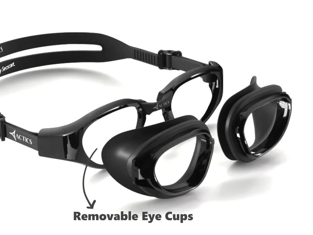 Black Actics swimming goggles by Specscart on a white background, demonstrating a modular design with an arrow pointing to the detached lenses labeled "Removable Eye Cups".