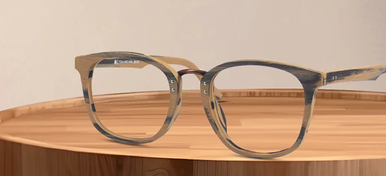 Round wooden-finish glasses resting on a polished timber stump, showcasing the natural grain texture and eco-friendly style of the frames.