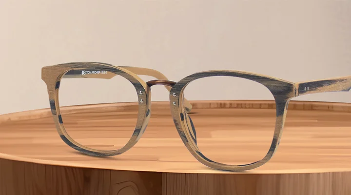 Round wooden-finish glasses resting on a polished timber stump, showcasing the natural grain texture and eco-friendly style of the frames.