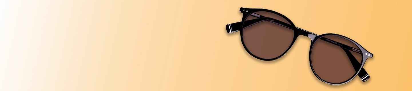 A pair of classic round sunglasses with black frames and brown tinted lenses, laid flat against a warm yellow and cream gradient background.