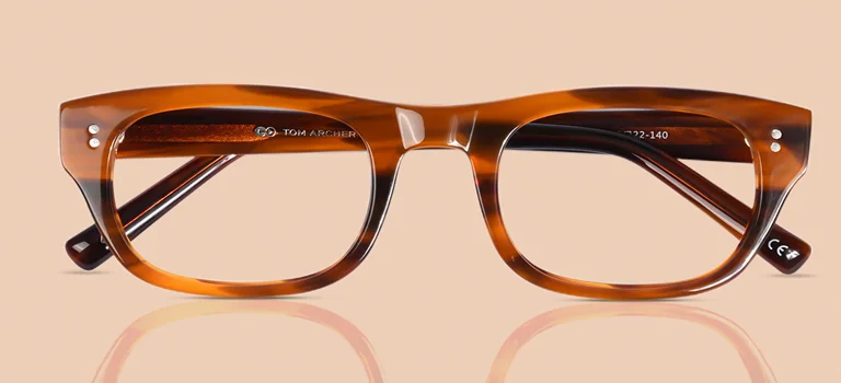 Glossy brown acetate glasses with a striped tortoiseshell pattern on a beige background, showcasing a classic rectangular frame style.